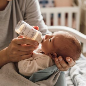 parent bottle-feeding their baby